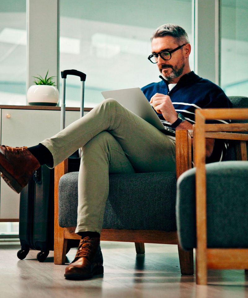 An office worker in an airport lounge, typing on a laptop.