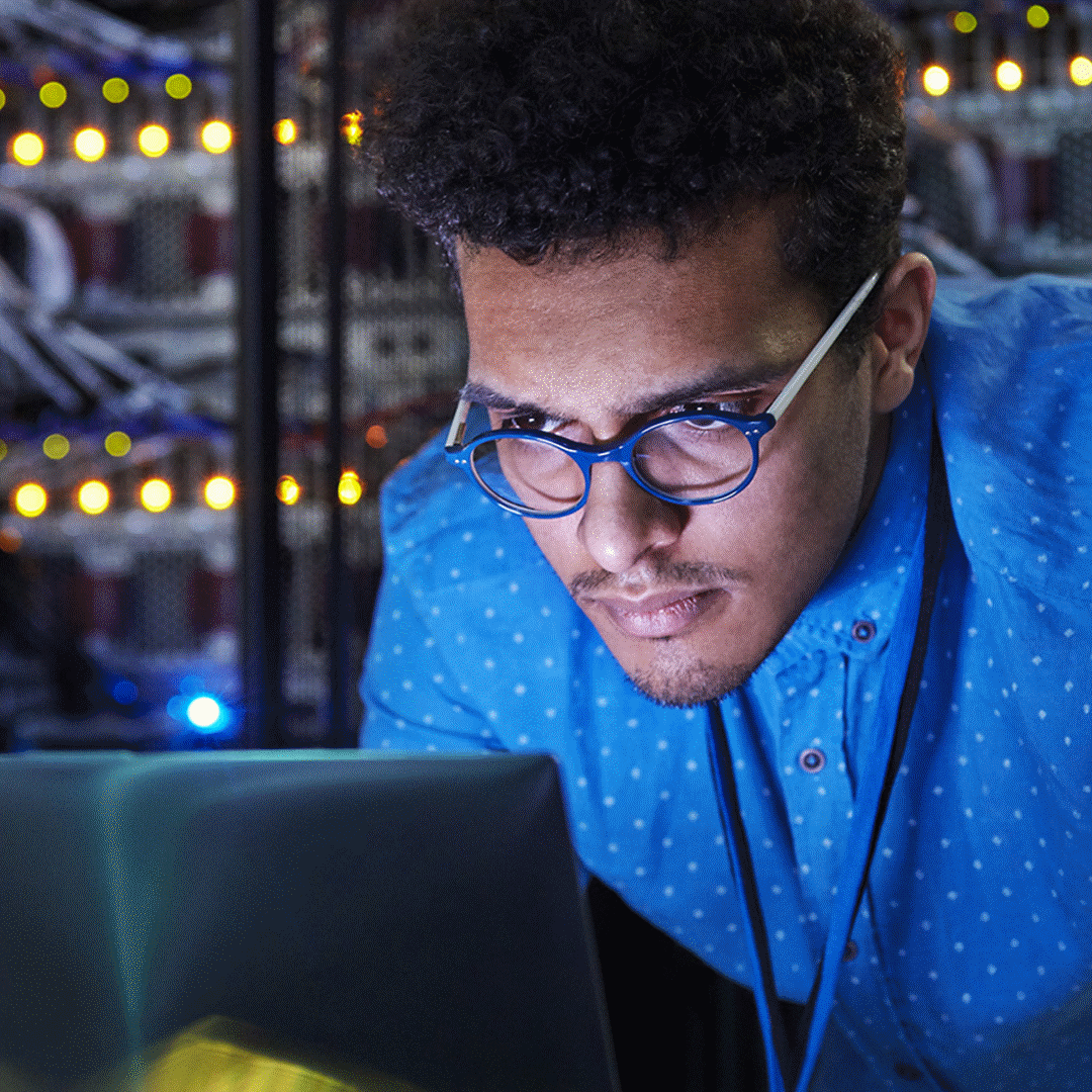 Engineer working on a laptop in a server room