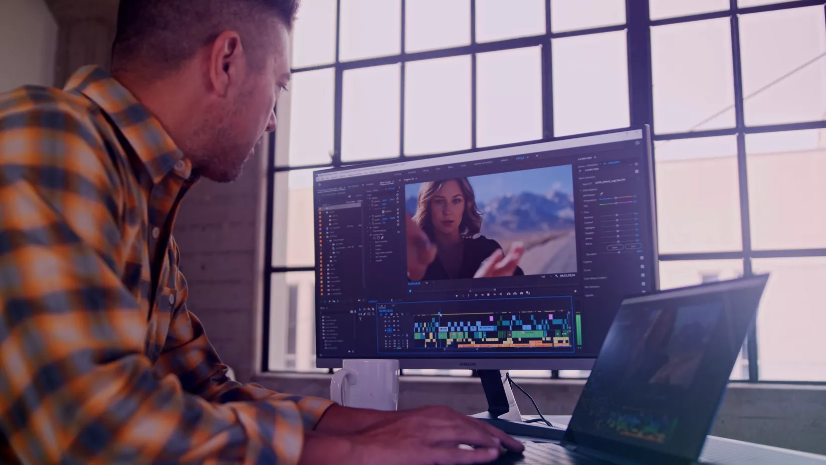 Người dùng đang chỉnh sửa video trên máy tính xách tay trong khi nhìn vào màn hình