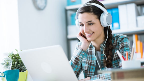Girl with headphones using a laptop