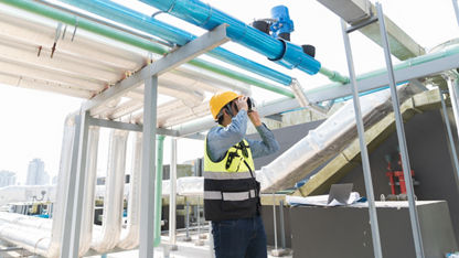 A worker in protective gear inspects a waterpipe network system.