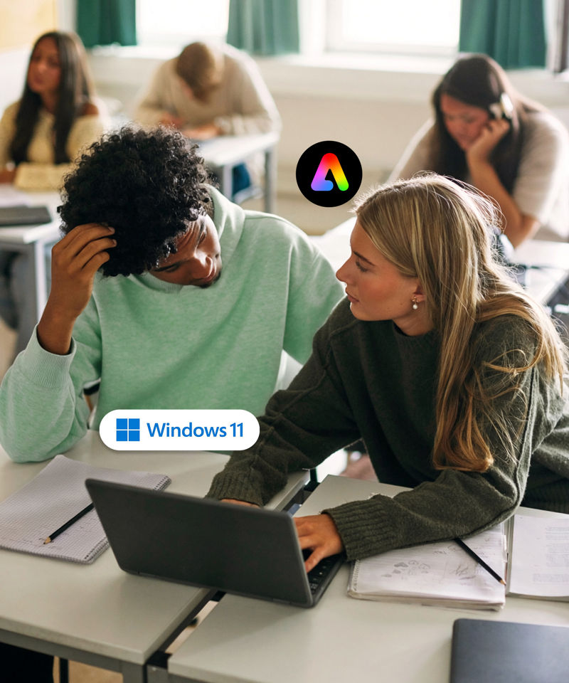 High angle view of male and female friends studying together on laptop in classroom at school