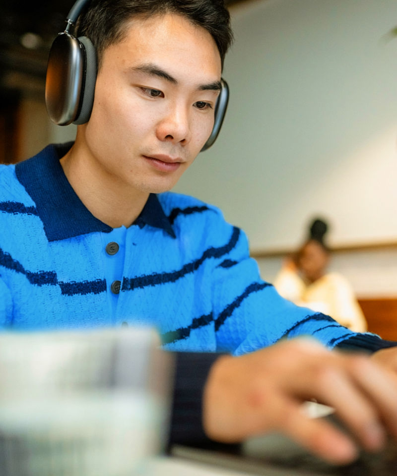 A man uses a laptop in a cafe