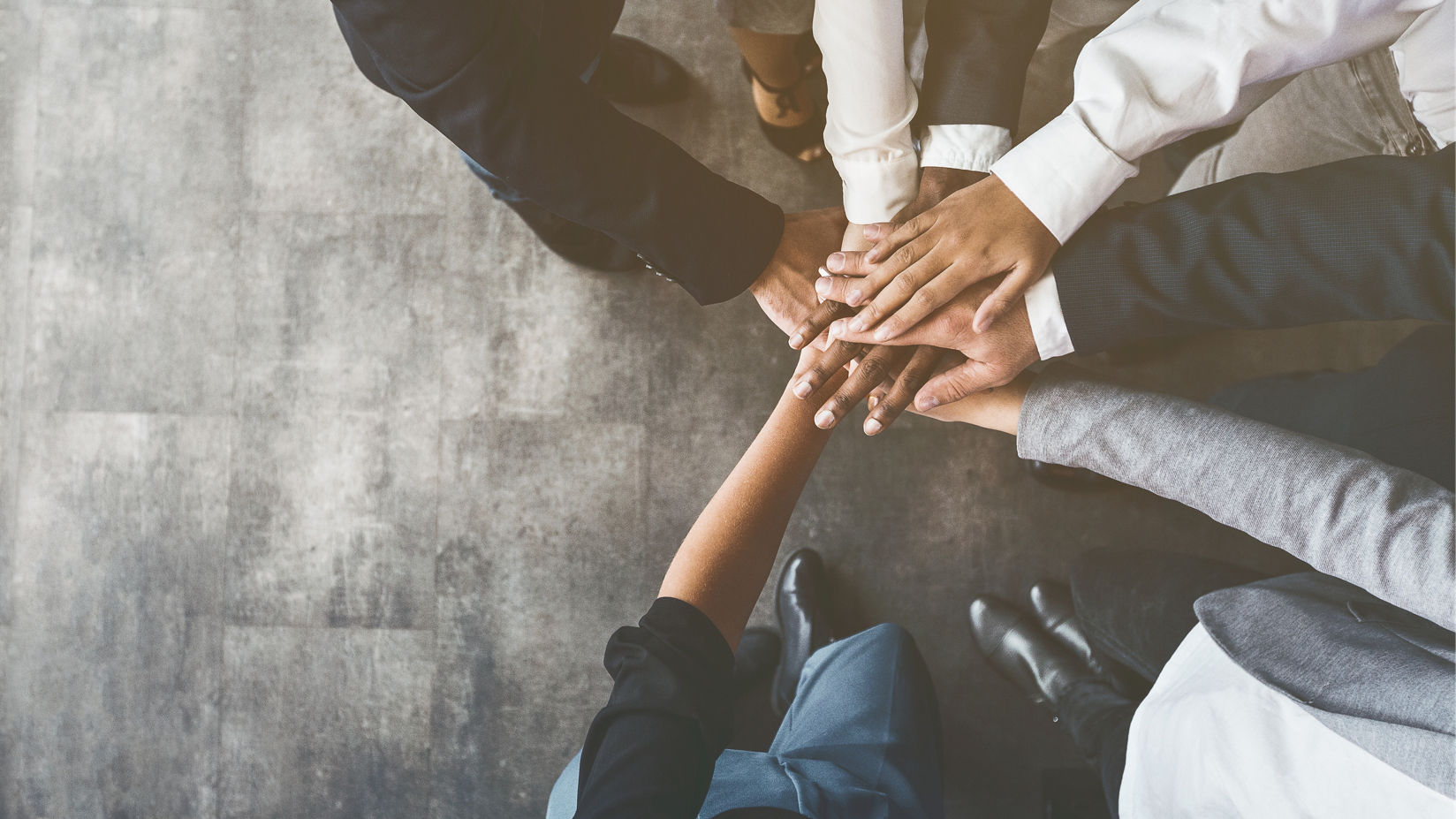 Diverse group of people putting their hands together