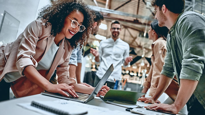 A diverse group of people work on a project.