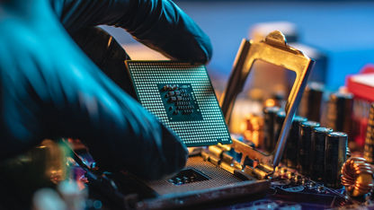 A gloved hand working on a CPU.