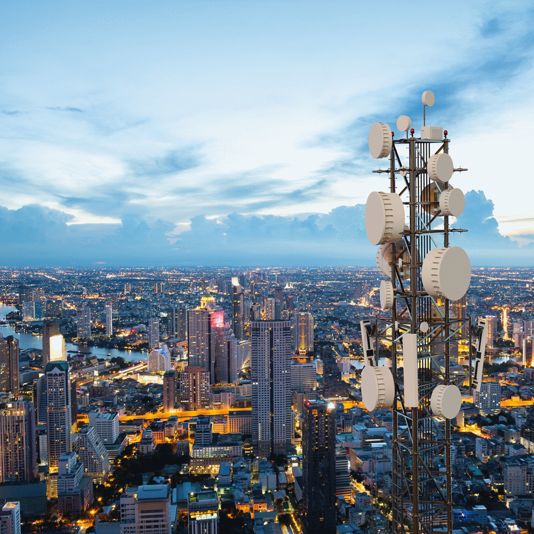 Telecommunication tower with 5G cellular network antenna on night city background.