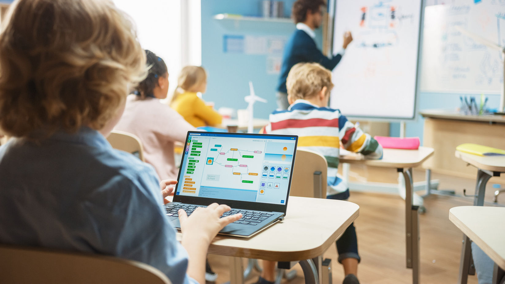 Student using a laptop in a classroom while engaging in technology-based learning