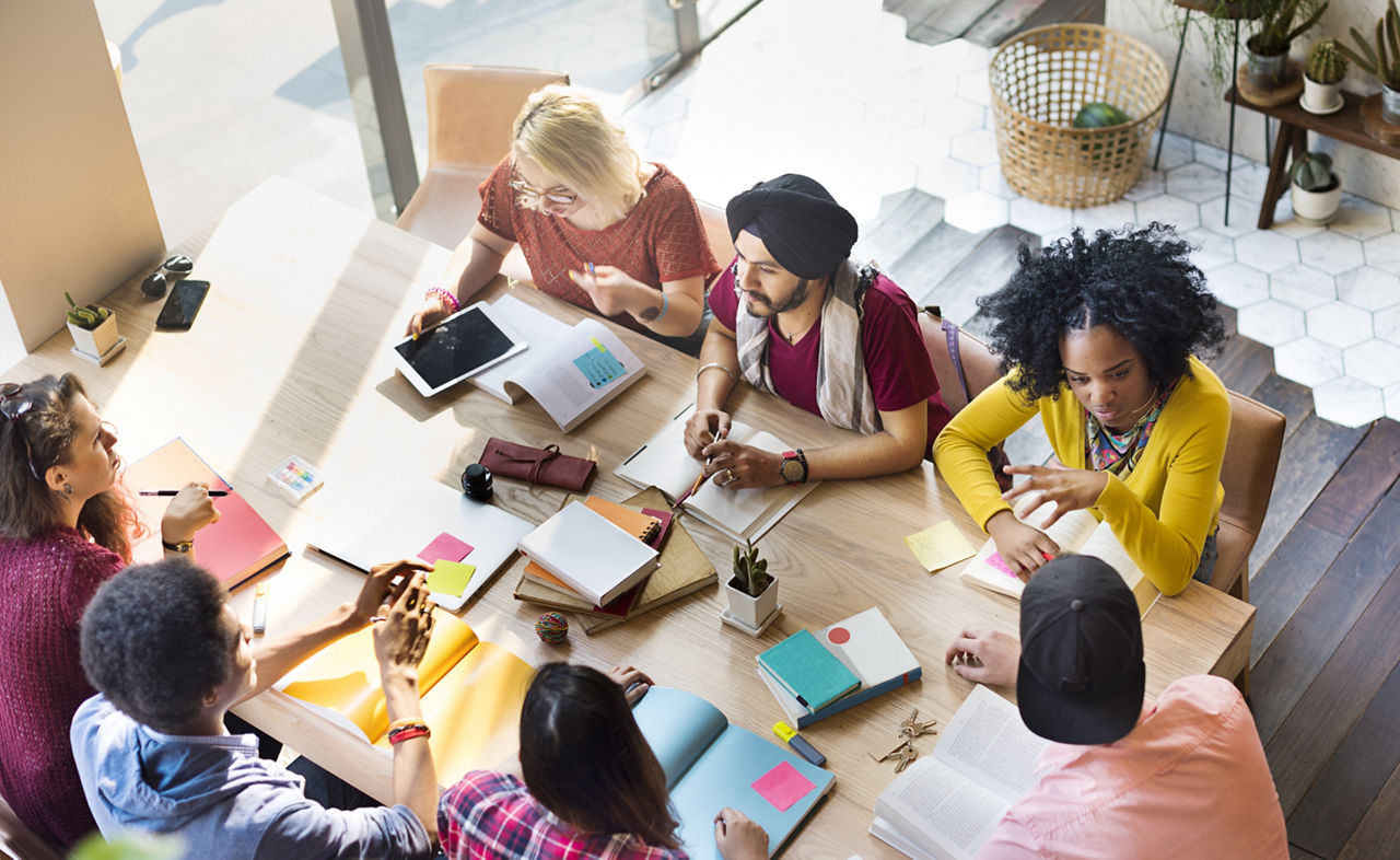 Overhead view of a diverse group of people talking at a table