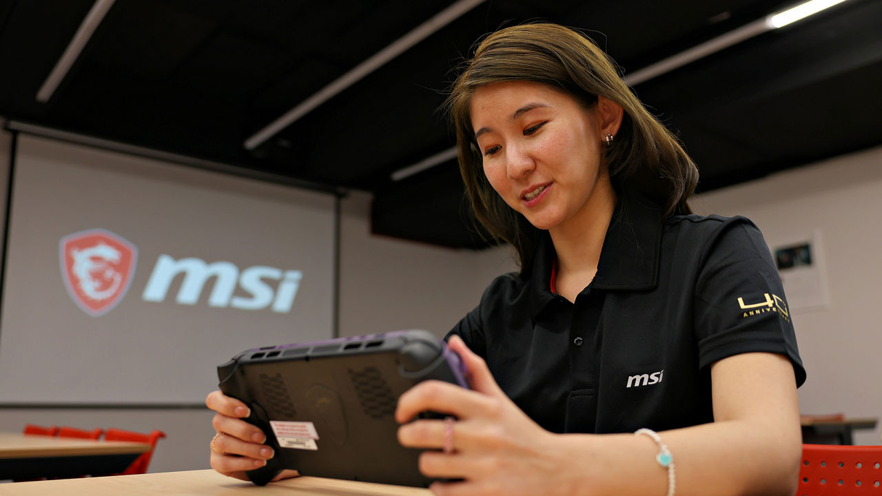 Pessoa usando um dispositivo portátil MSI em uma sala com a marca MSI ao fundo.