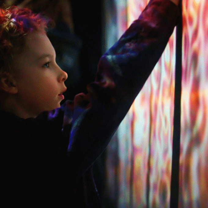 Child interacting with a colorful digital display