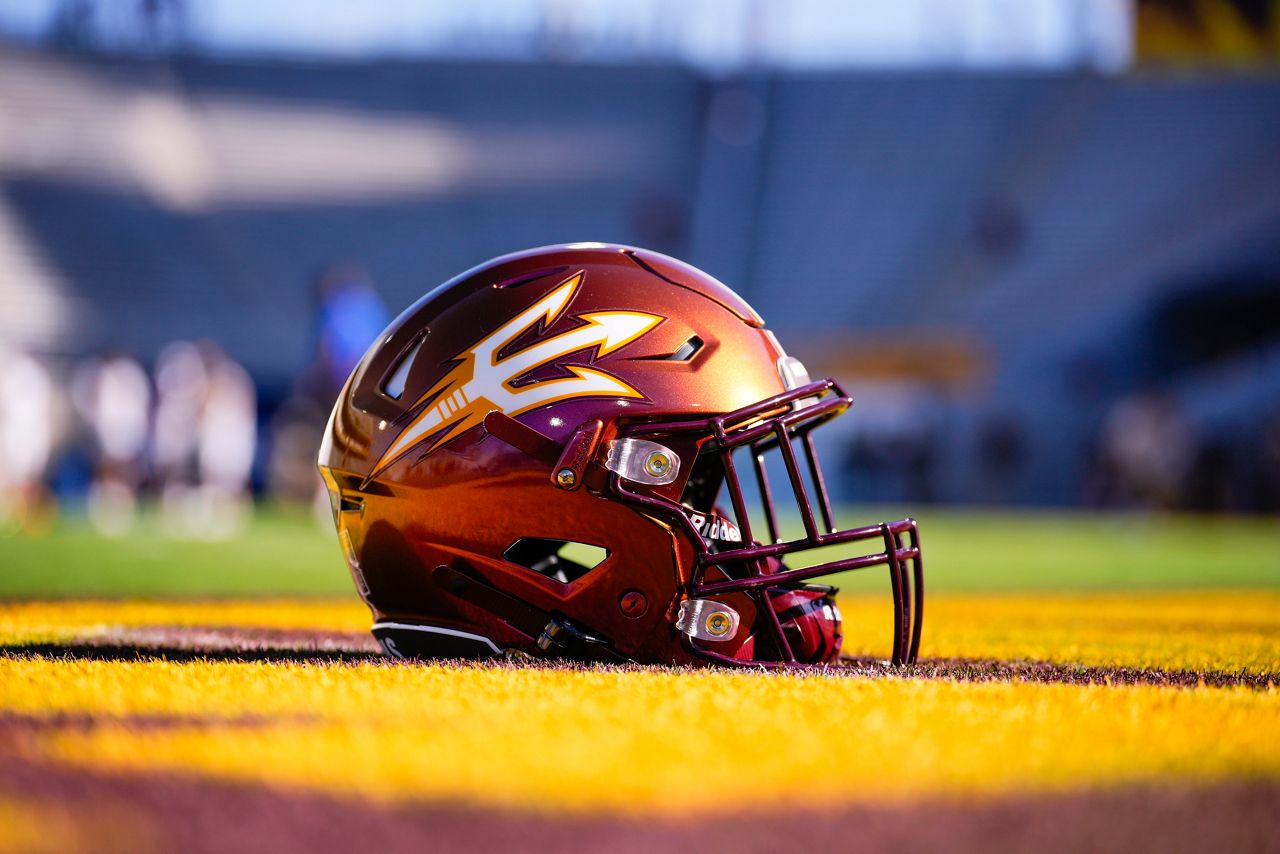 Arizona Stated copper colored footbal helmet laying on a field