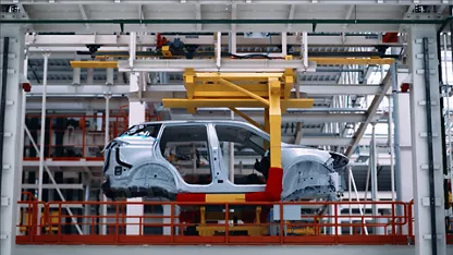 A side view of a car body frame on an assembly line in a high-tech factory