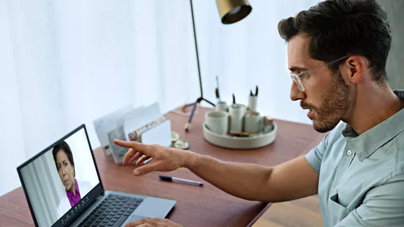 ビデオ会議でノートブック PC を使用する男性