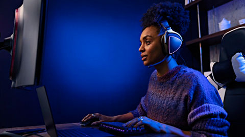 Gamer perempuan di rumah memakai headset
