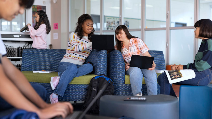 Students partnering together to study in school lounge