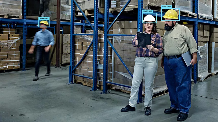 two warehouse workers with hard hats indicated