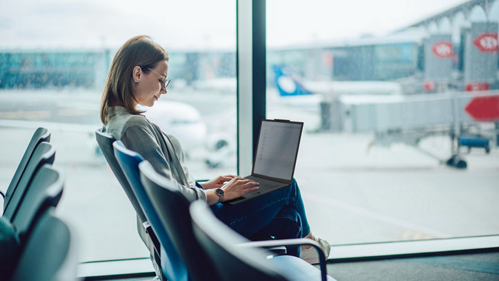 Female individual working on a laptop in an airport