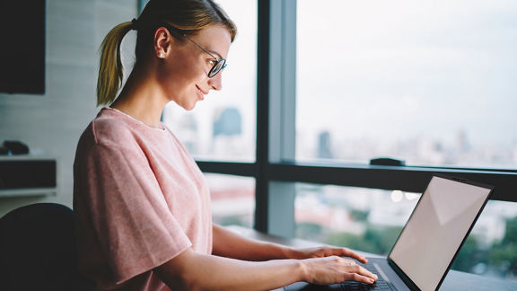 Female individual working on a laptop in a remote setting