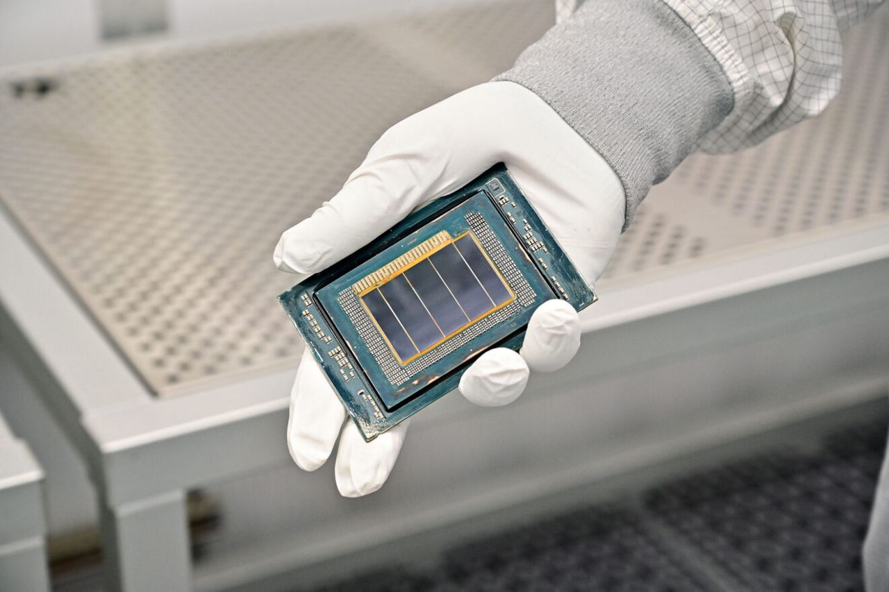 An Intel manufacturing technician holds a Clearwater Forest chip inside the cleanroom of Intel’s new Fab 52 in Chandler, Arizona, in September 2025. Fab 52 is the U.S. home to Intel 18A, where Clearwater Forest, a data center processor, will be manufactured.