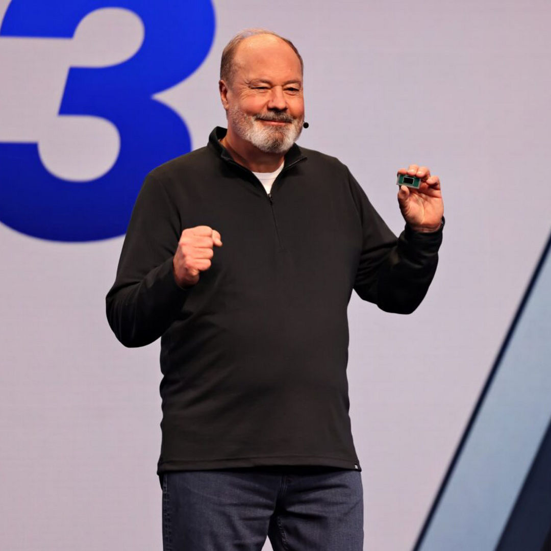 Presenter holding an Intel processor onstage.