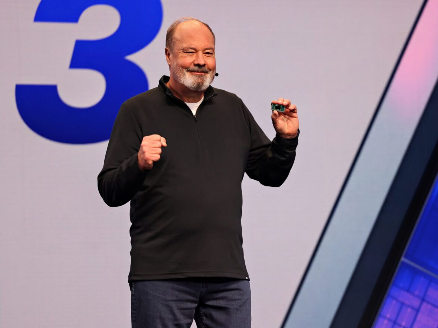 Presenter holding an Intel processor onstage.