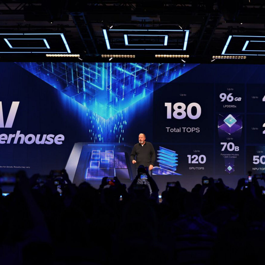 Presenter onstage with an Intel AI performance presentation.