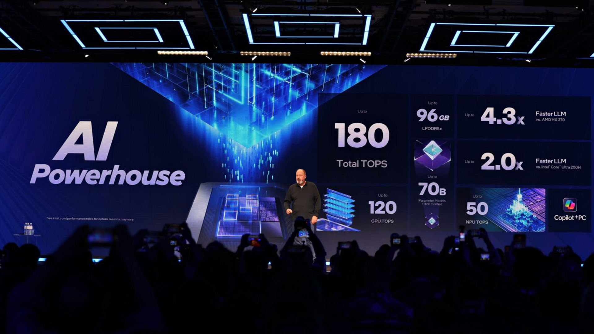 Presenter onstage with an Intel AI performance presentation.