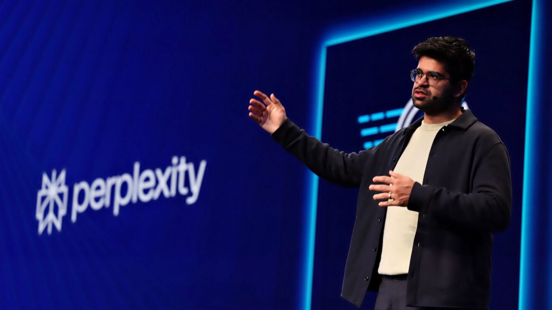 Presenter onstage with a Perplexity demonstration.