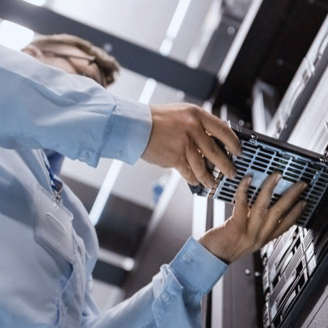 Technician installing a server component into a data center rack