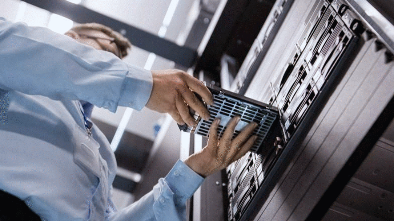 Technician installing a server component into a data center rack