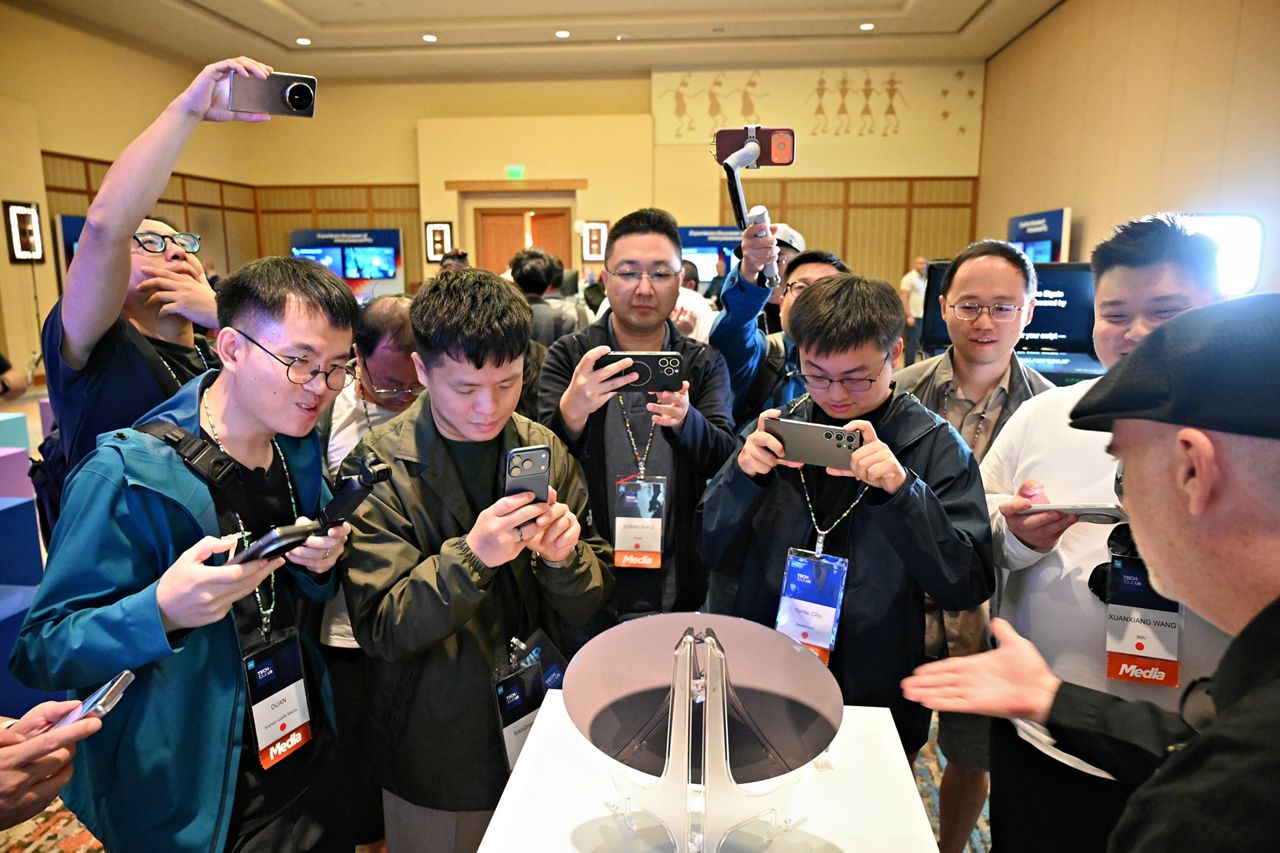 Attendees photograph an Intel Core Ultra series 3 wafer.