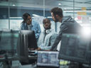 Three coworkers looking at desktop monitor together