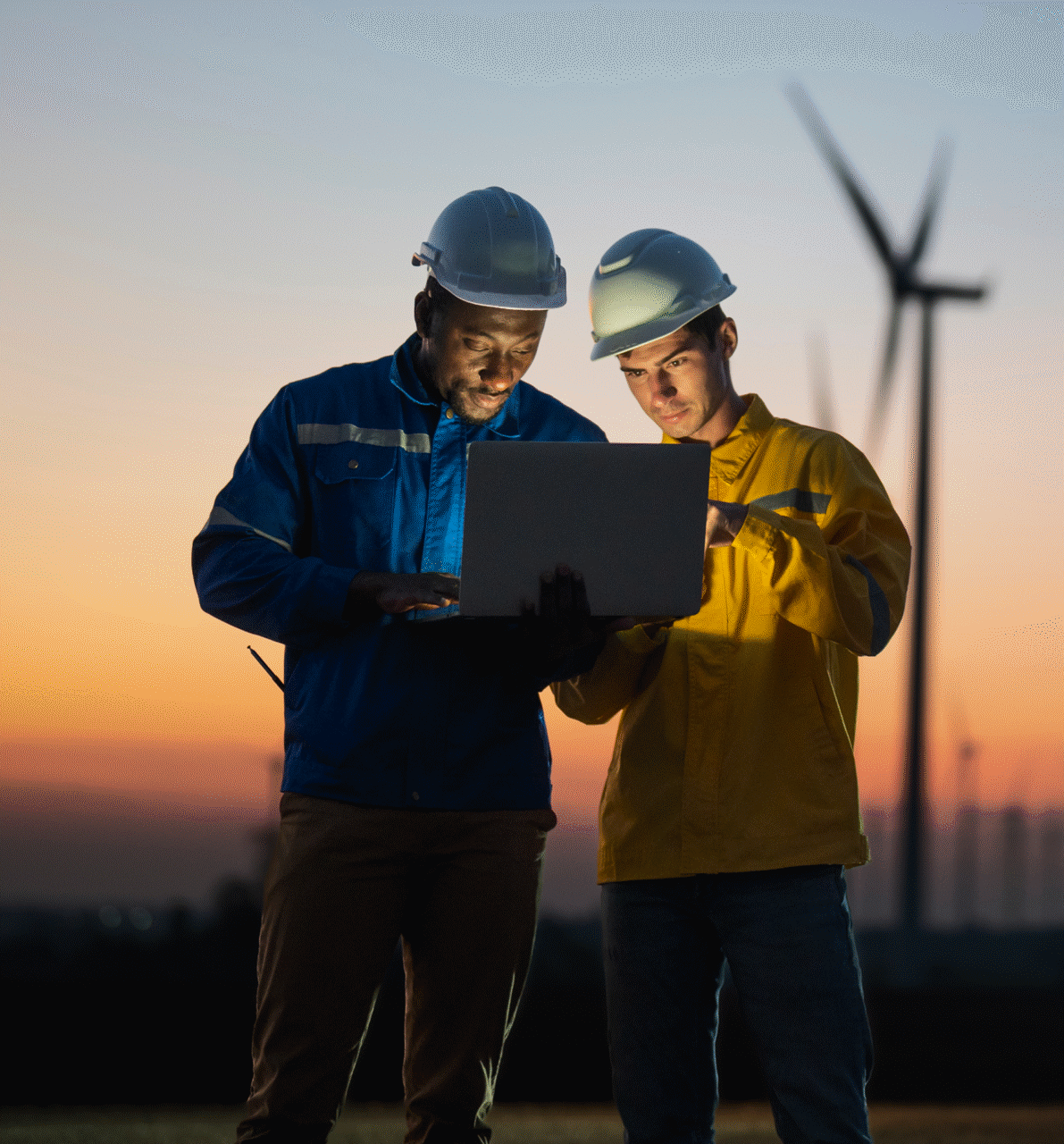 Workmen with laptop and windmills
