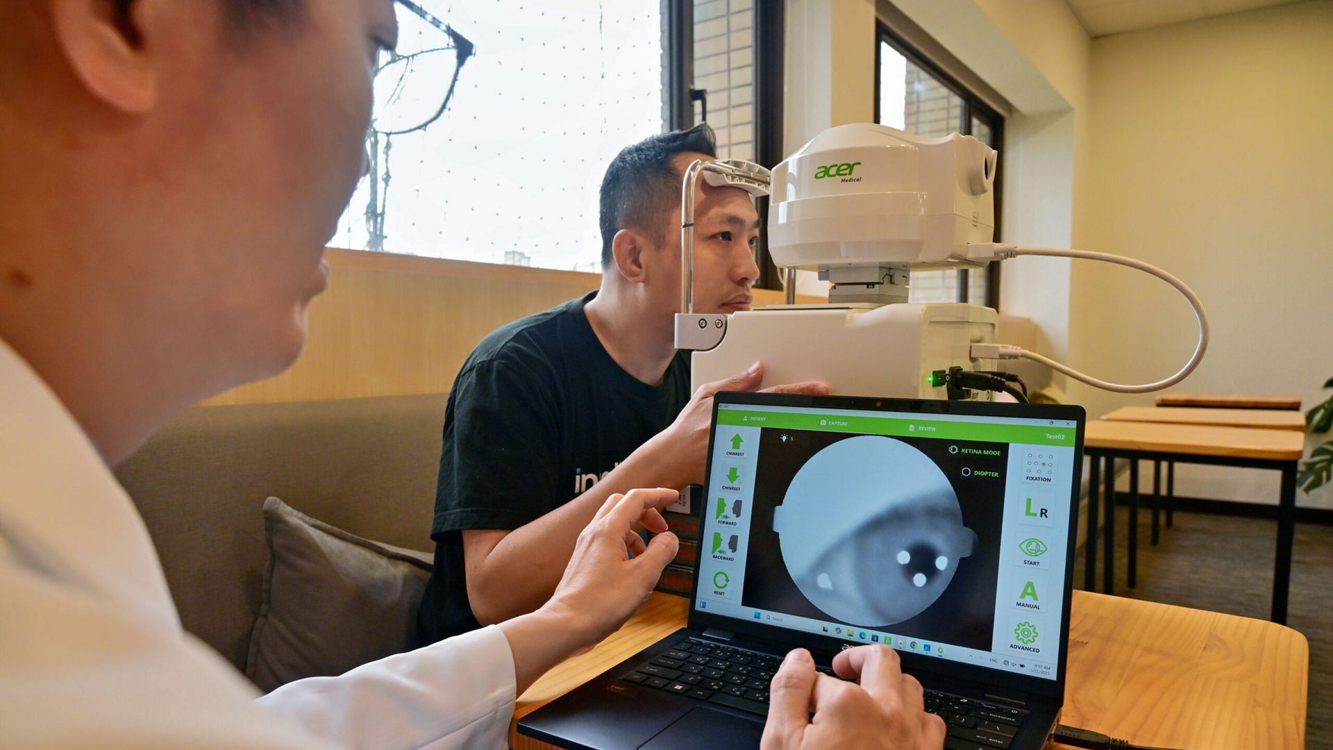 Dr. Hsieh Yi-Ting (foreground) demonstrates detailed eye scans of a patient on his Acer Travelmate Spin P4 AI PC, connected to a high-resolution fundus camera. Thanks to AI algorithms developed using Intel OpenVINO tool kits, the medical team sees results in just 10 seconds. (Credit: Intel Corporation)