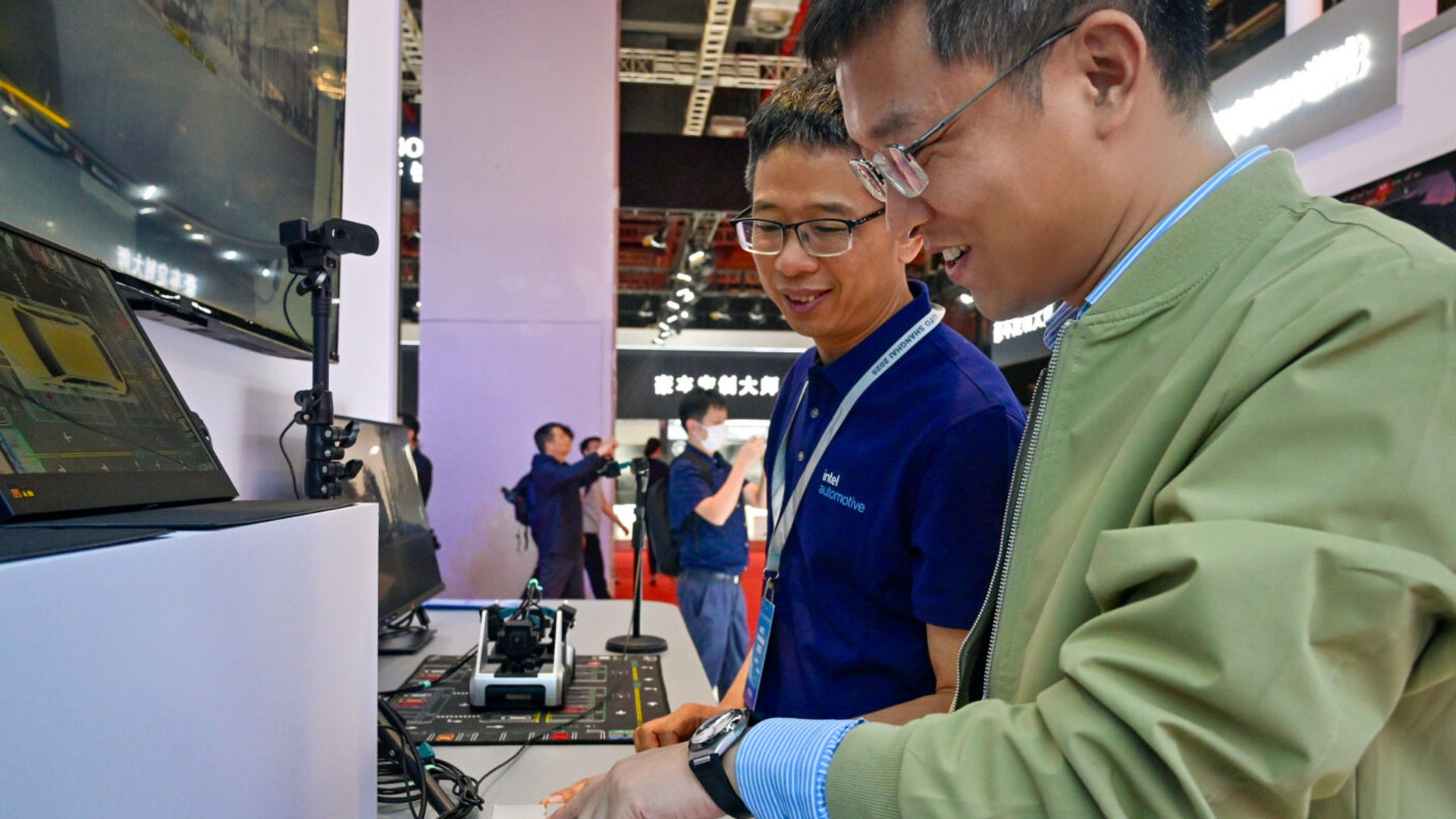 Intel experts and visitors interact with automotive technology at the Intel booth during Auto Shanghai.