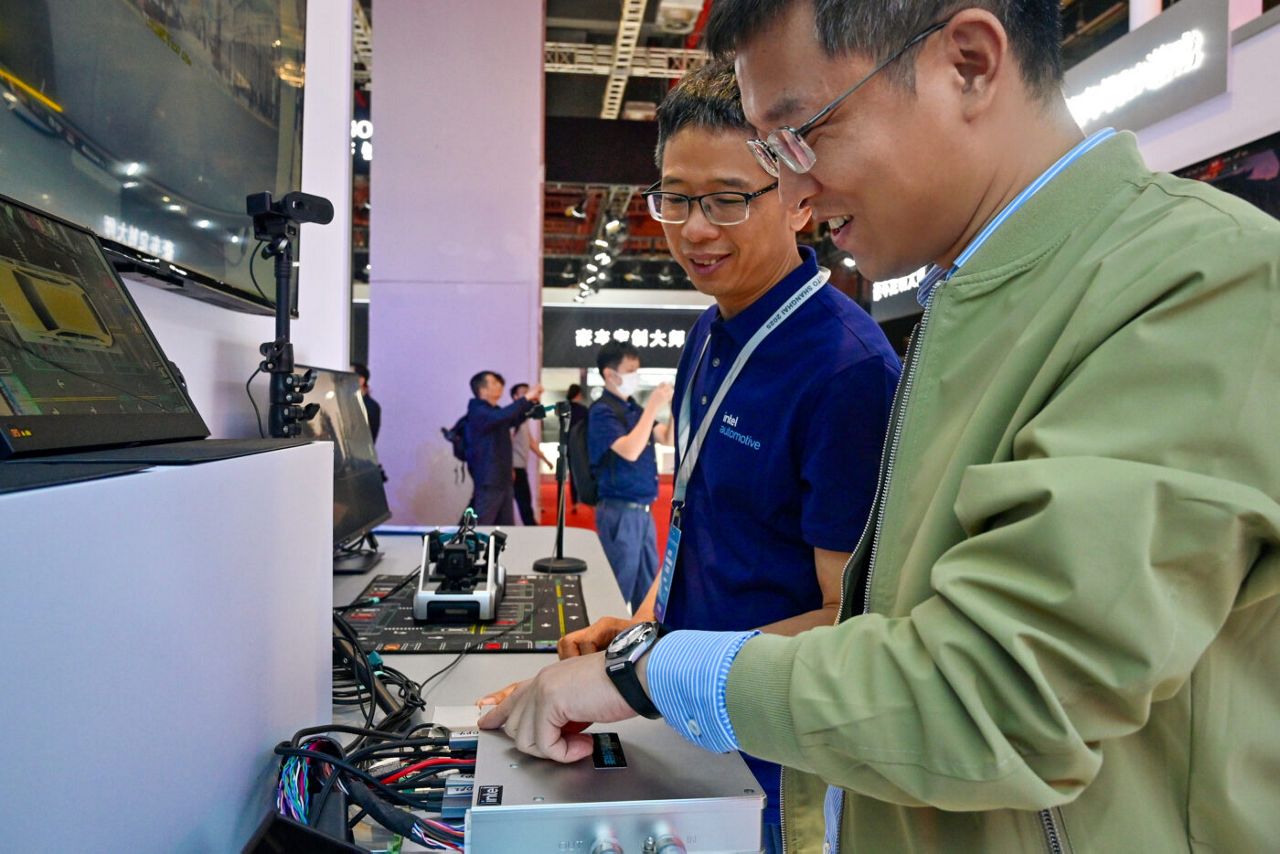 Visitors and Intel demo experts tour the Intel booth at the Auto