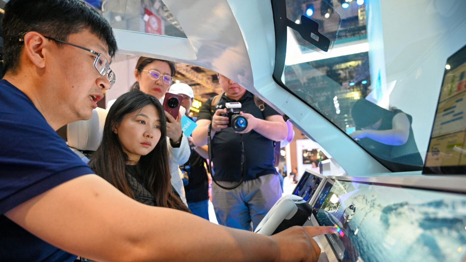 An Intel expert demonstrates automotive technology to visitors at the Intel booth during Auto Shanghai.