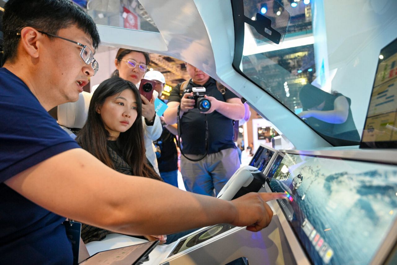 Visitors and Intel demo experts tour the Intel booth at the Auto
