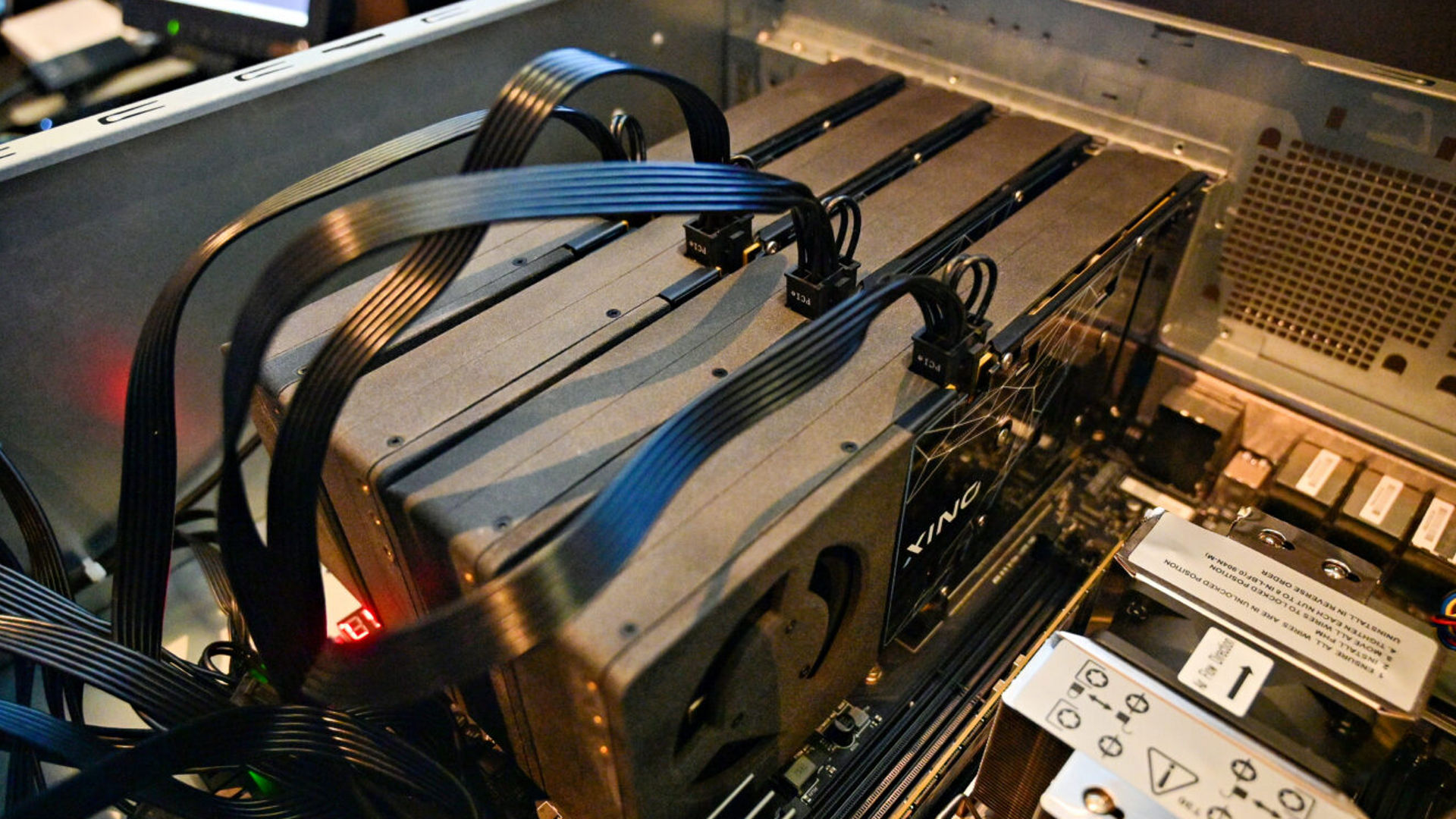 Multiple graphics cards installed inside a workstation chassis with connected power cables.