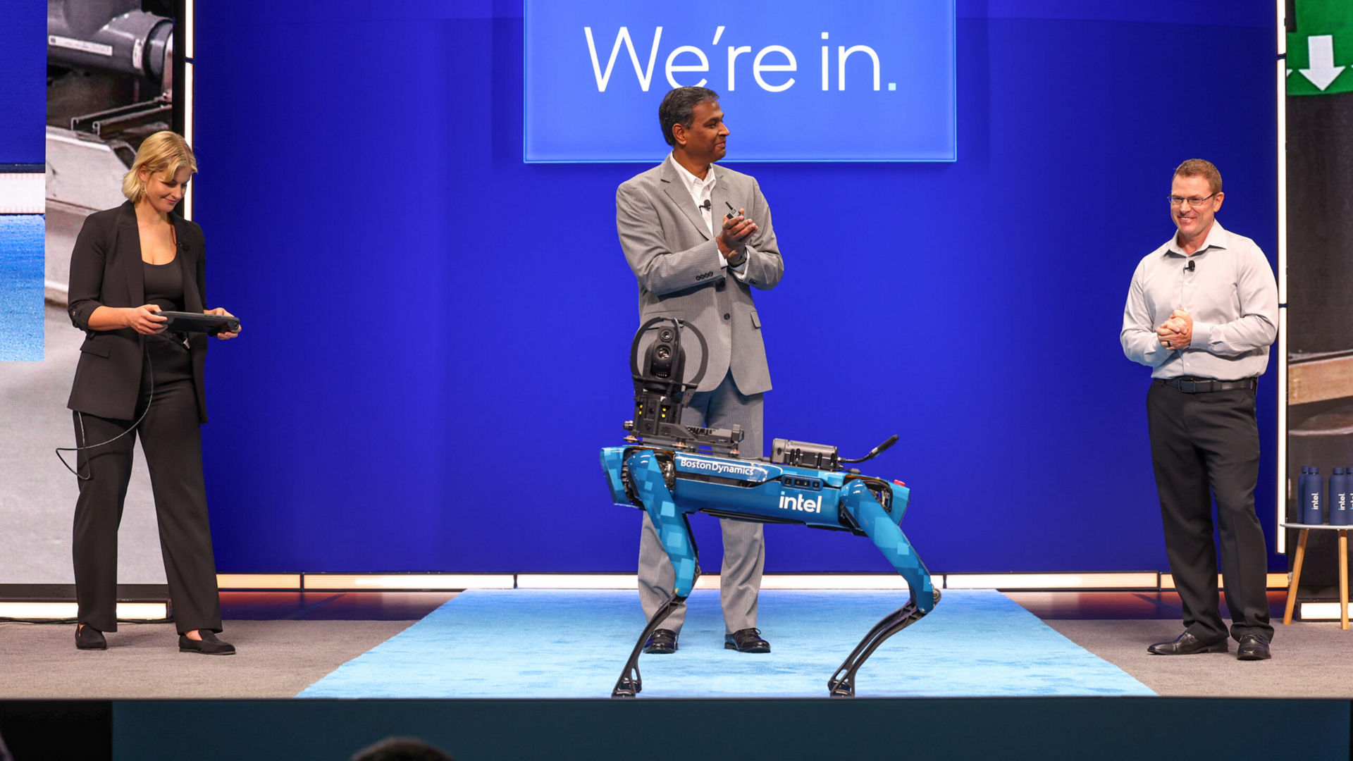 Jessica Unwin, Naga Chandrasekaran, and Joe Robison demonstrate a robotic dog at an Intel Foundry keynote.