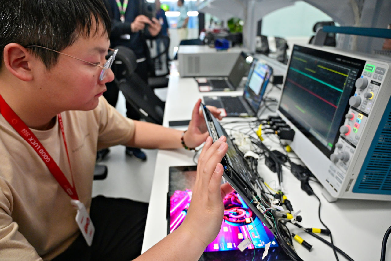 At Lenovo’s Advanced Co-Engineering Lab in Shanghai, China, Lenovo electronics engineer Xia Shengqiang analyzes the inner workings of a Lenovo Aura Edition PC in April 2025. (Credit: Intel Corporation)