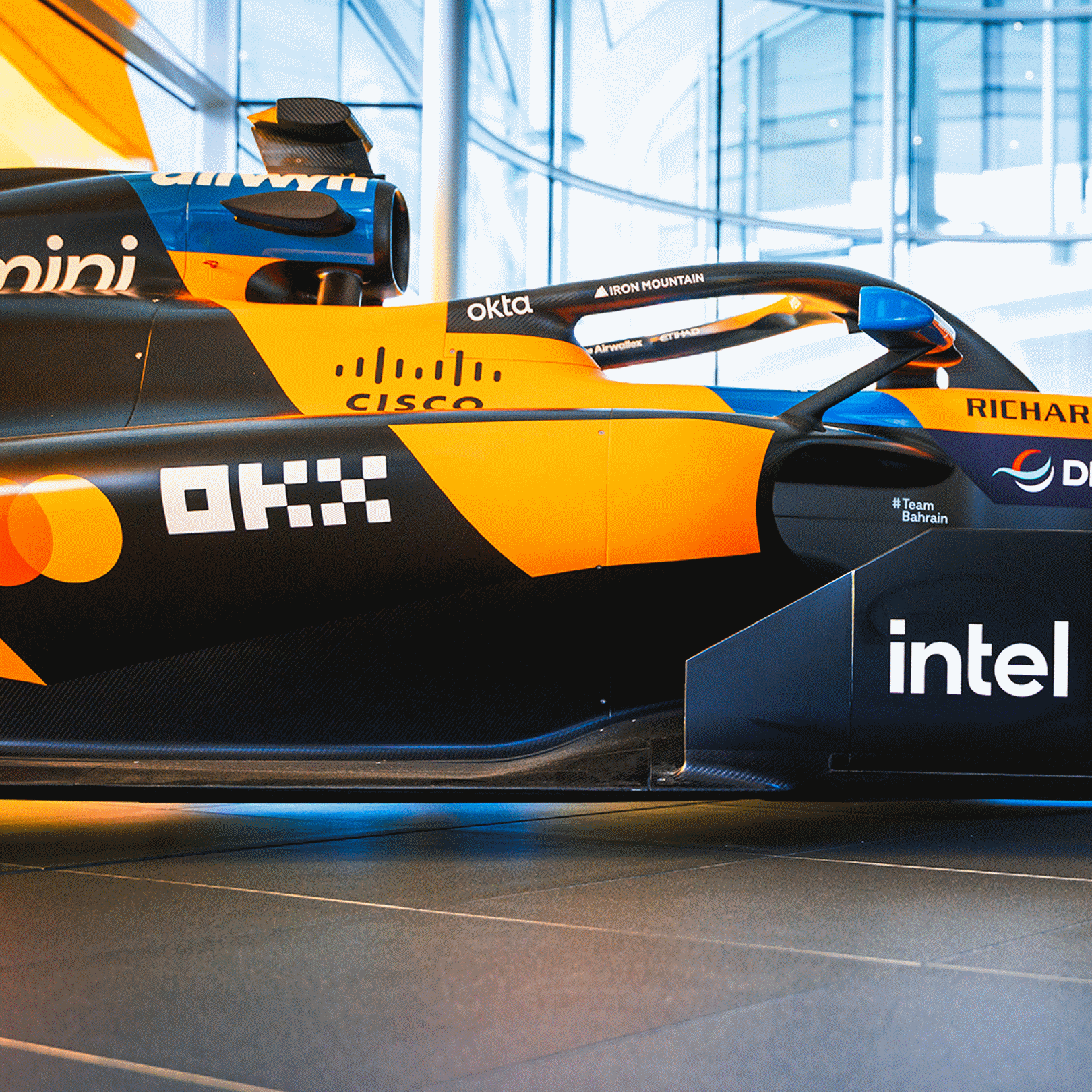 Side view of an orange and black McLaren Formula 1 race car featuring the Intel logo.