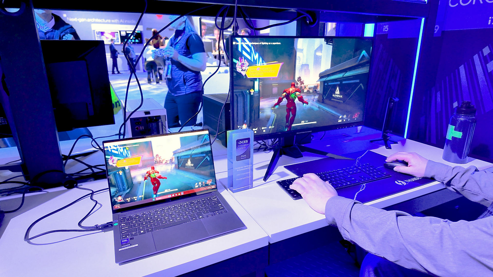 A desktop monitor and laptop show the same futuristic game scene in a Thunderbolt Share demonstration.