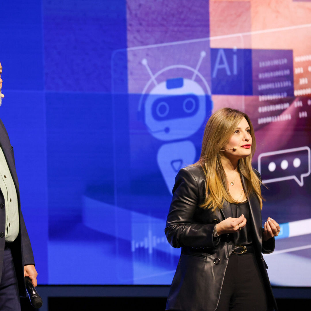 Dounia Senawi (right), Deloitte Consulting’s chief commercial officer, appears on stage with Jim Johnson, general manager of the Client Computing Group at Intel, during the Intel Vision event on Tuesday, April 1, 2025, in Las Vegas. Senawi discussed Deloitte’s strategic investment in a fleet of Intel Core Ultra AI PCs for its developers, and she reported the company has seen a 50% time savings in completing routine tasks. (Credit: Intel Corporation)