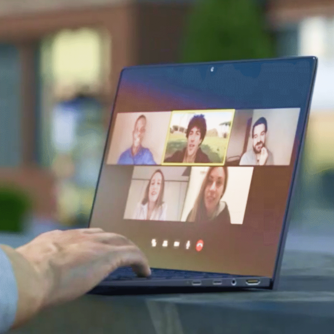 Hand on keyboard of laptop with 5 video chat windows on screen