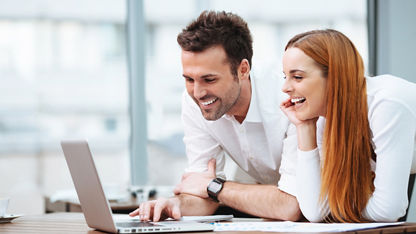 Một người đàn ông và một người phụ nữ đang làm việc trên cùng một chiếc máy tính xách tay
