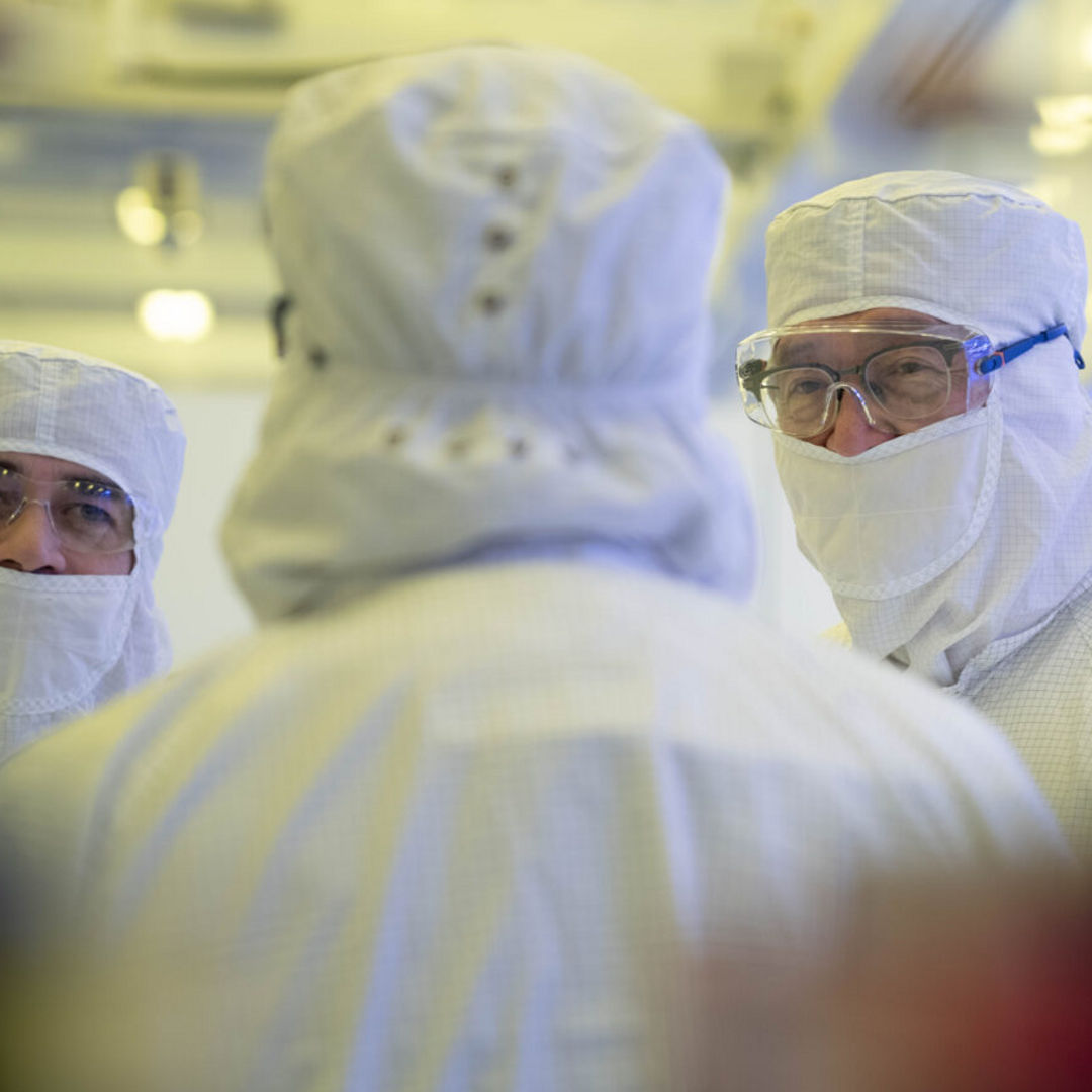 Intel CEO Lip-Bu Tan (right) listens as manufacturing leaders lead a tour inside Fab 52 on the Intel Ocotillo campus in Chandler, Arizona in October 2025. Anyone entering a semiconductor manufacturing environment must wear appropriate personal protective equipment (PPE), including what is popularly known as a "bunny suit," to protect the wafers and chips in production.