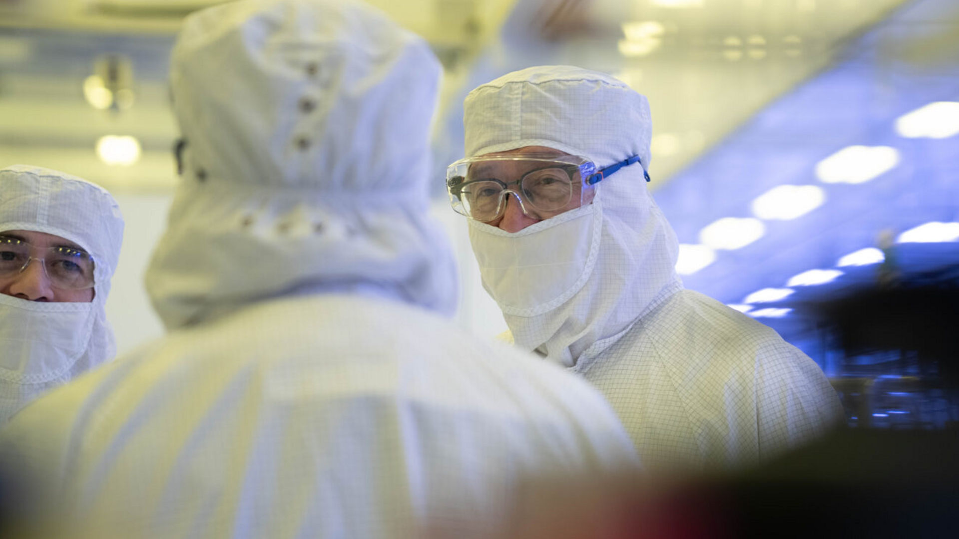 Lip-Bu Tan and others in white cleanroom suits tour Intel Fab 52.
