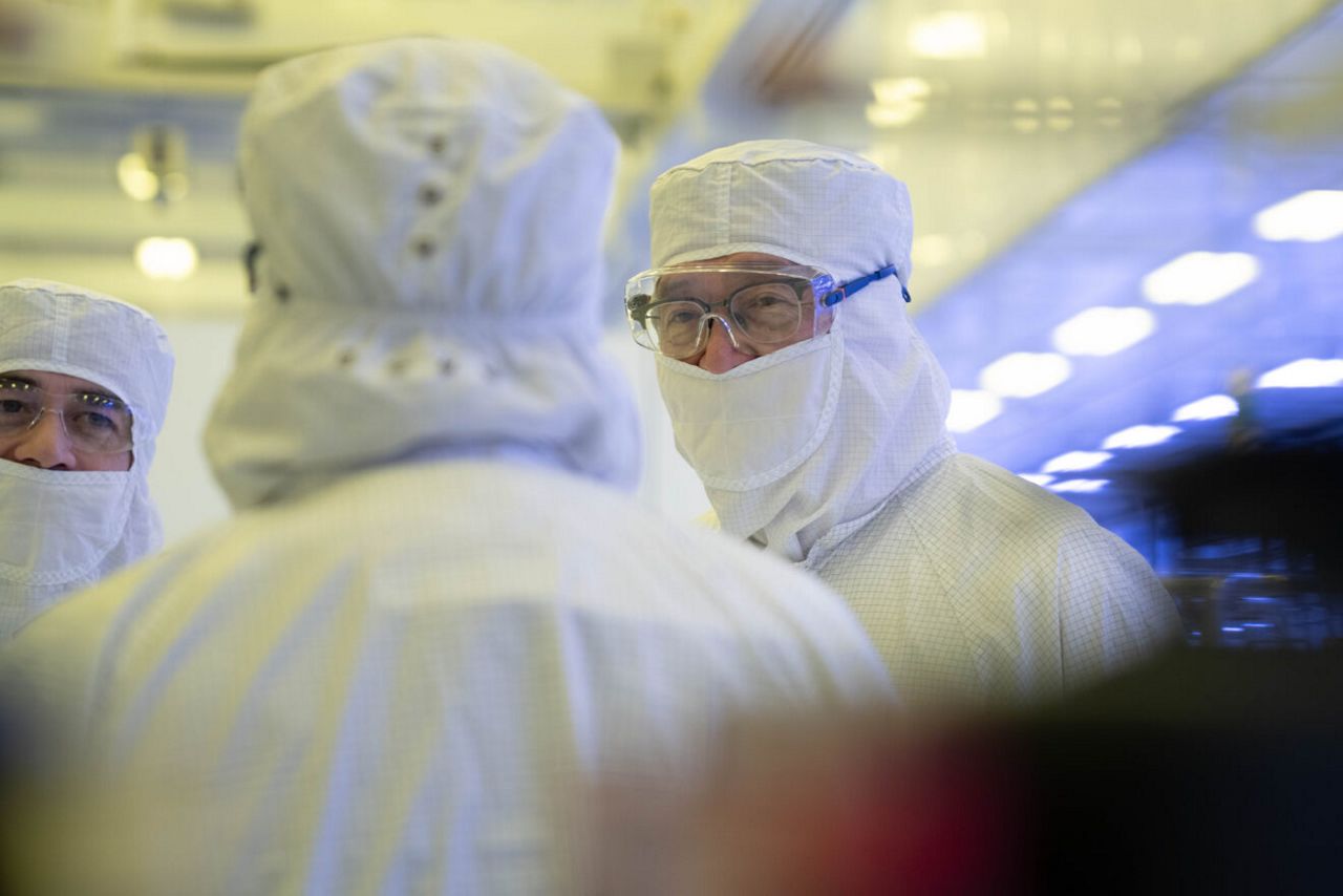 Intel CEO Lip-Bu Tan (right) listens as manufacturing leaders lead a tour inside Fab 52 on the Intel Ocotillo campus in Chandler, Arizona in October 2025. Anyone entering a semiconductor manufacturing environment must wear appropriate personal protective equipment (PPE), including what is popularly known as a "bunny suit," to protect the wafers and chips in production.
